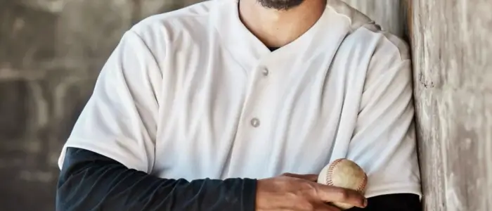 a baseball player in a jersey leaning against a wall