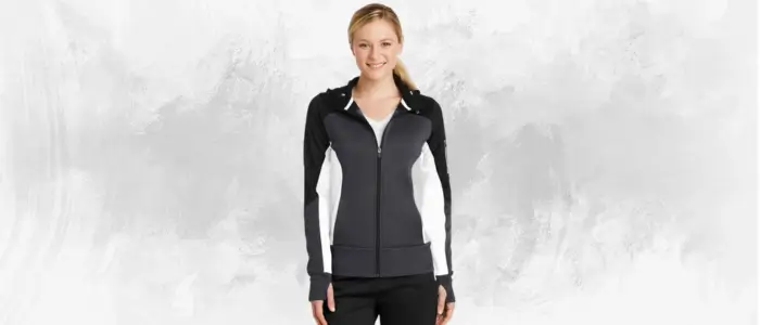 a woman in a black and white sport-tek ladies tech fleece full-zip hooded jacket