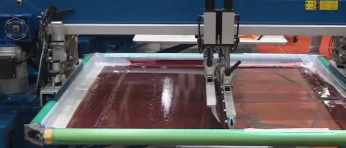  Red fabric being cut by machine for Flatbed Screen Printing