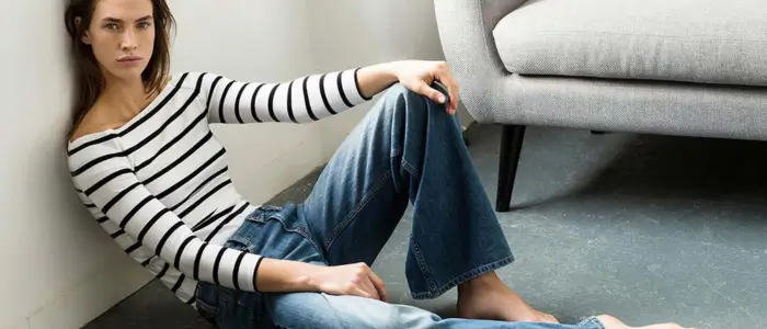 woman in boat neck t-shirt sitting cross-legged on floor