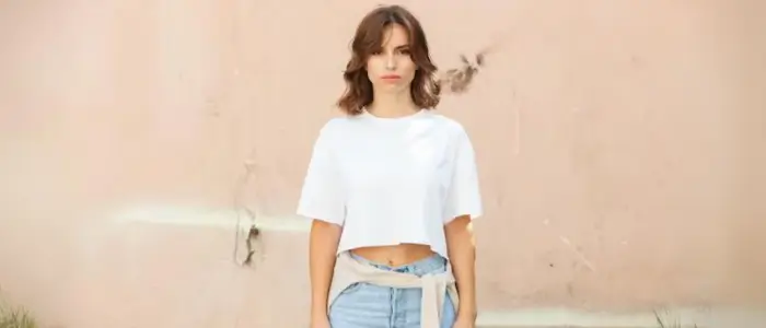 a woman in a white crop t-shirt and jeans