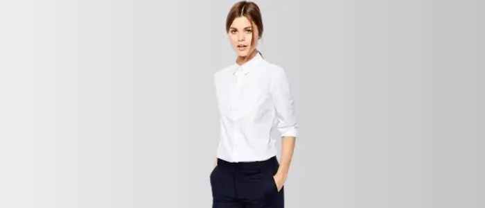 a woman in a white dress shirt and navy pants