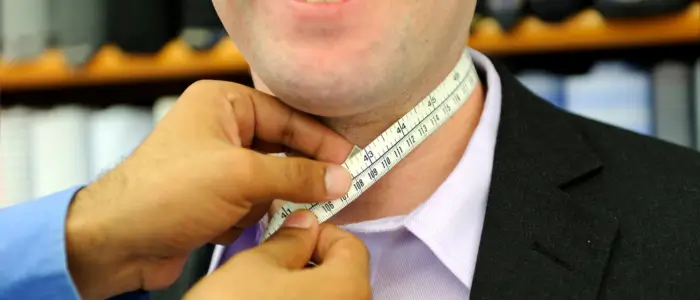 man measuring his neck with a tape measure