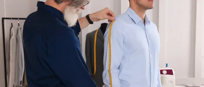 a man in suit measuring shirt sleeve length