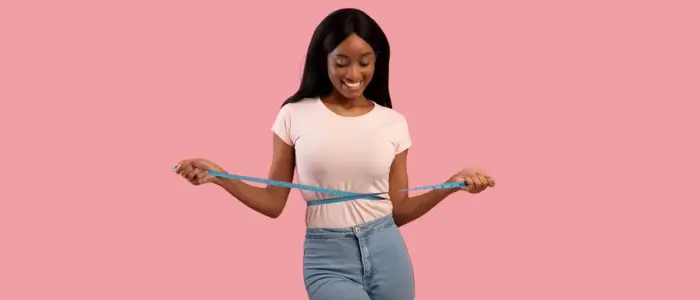 a woman using a measuring tape to measure her waist