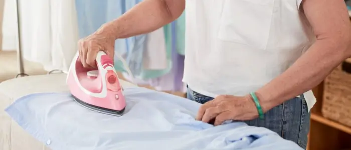 a man ironing a shirt on an ironing board