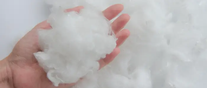  a person holding a white fluffy material made of polyester, shrinking