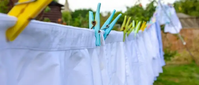 white nylon clothes hanging on pegs